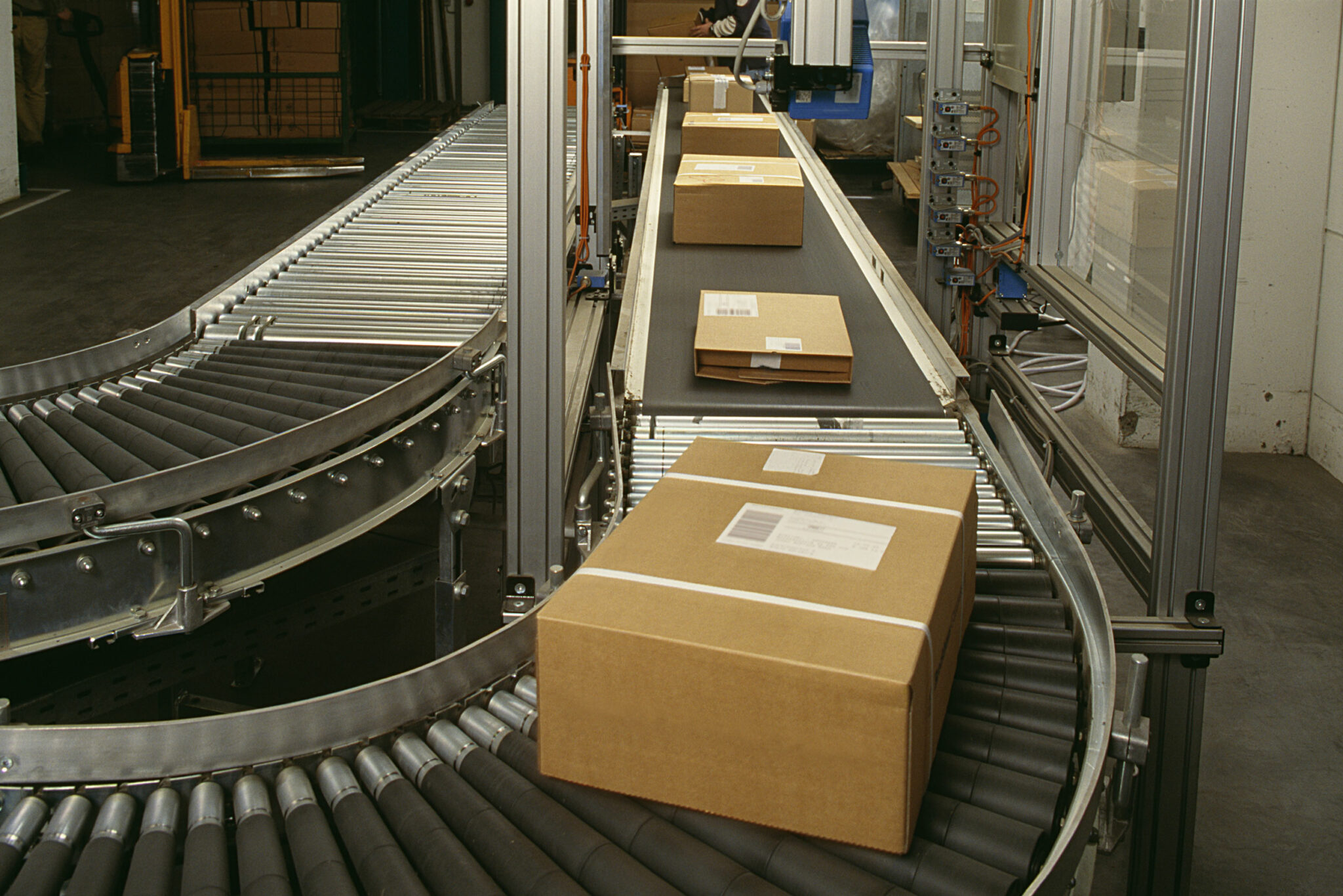 Die Kartons werden auf einer automatisierten Förderanlage im Lager transportiert und durchlaufen dabei ein Sortiersystem.