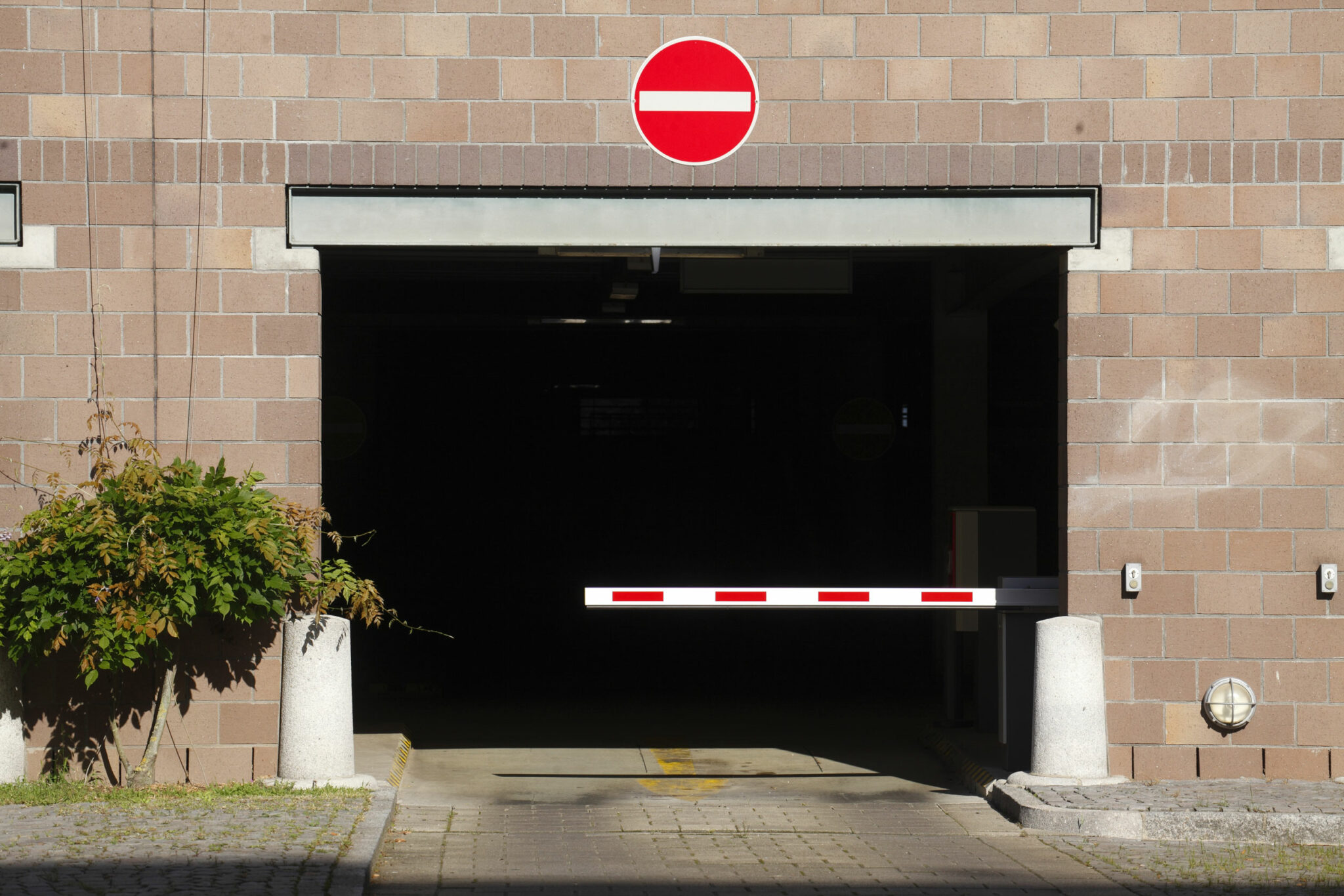 Am Eingang zur Tiefgarage sind eine Schranke und ein Schild mit der Aufschrift „Einfahrt verboten“ angebracht, die den Zugang für Fahrzeuge einschränken.